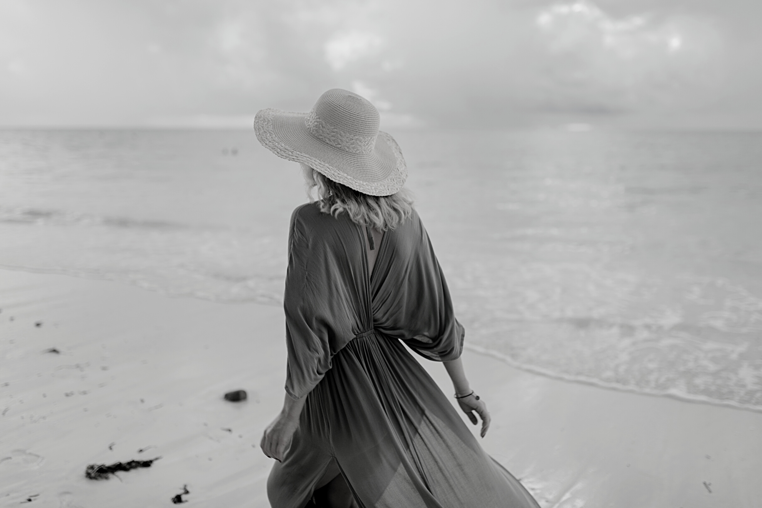 Woman with flying dress standing on wet beach