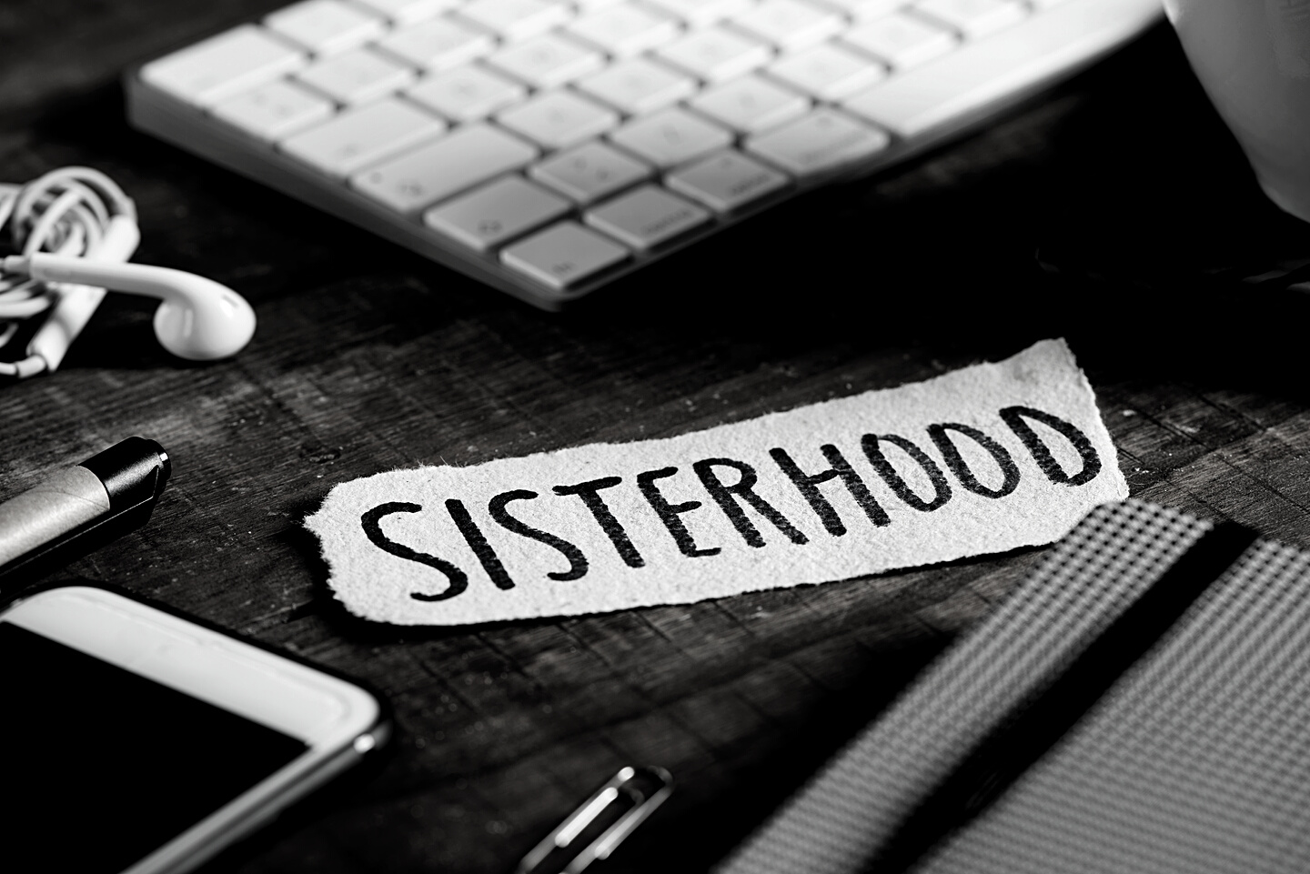 text sisterhood in a piece of paper on a table